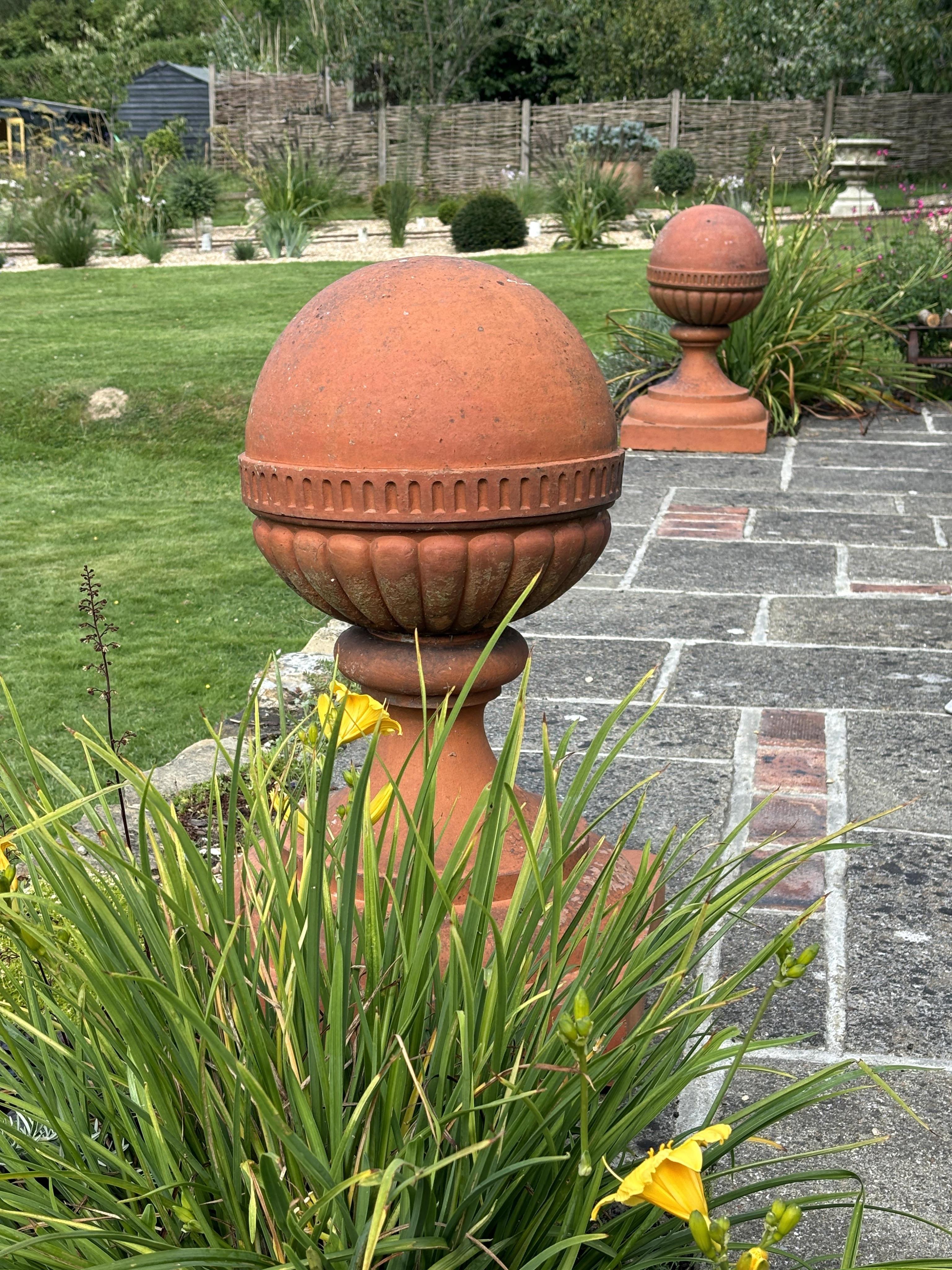 A large pair of Victorian terracotta ball finials, height 64cm, diameter 46cm. Condition -weathered, some chipping to the bases